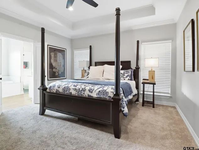 a bed sitting in a bedroom next to a window with pc on the table