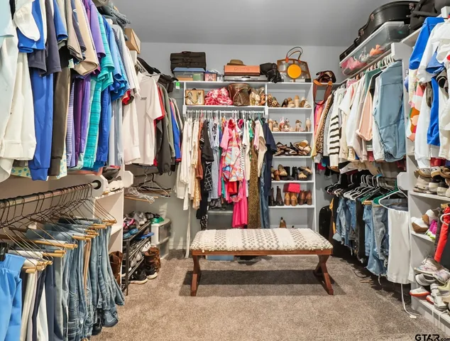 a view of walk in closet with clothes