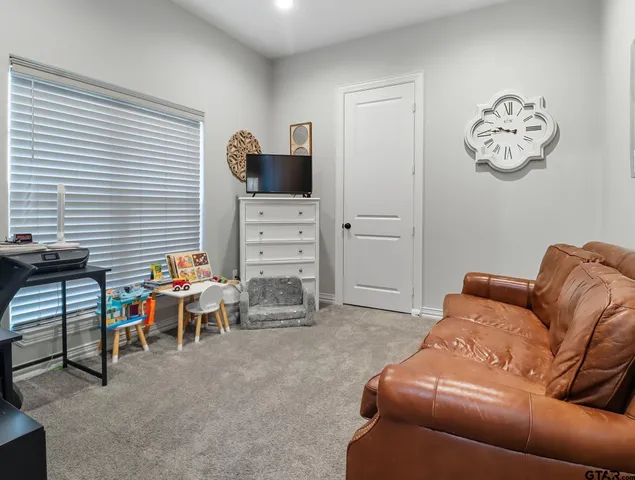 a living room with furniture a flat screen tv and a window