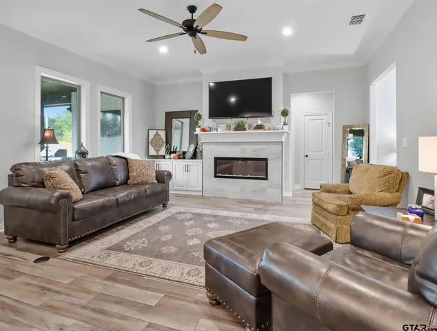 a living room with furniture a fireplace and a flat screen tv
