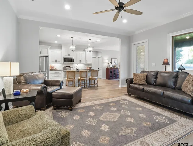 a living room with furniture kitchen view and a chandelier