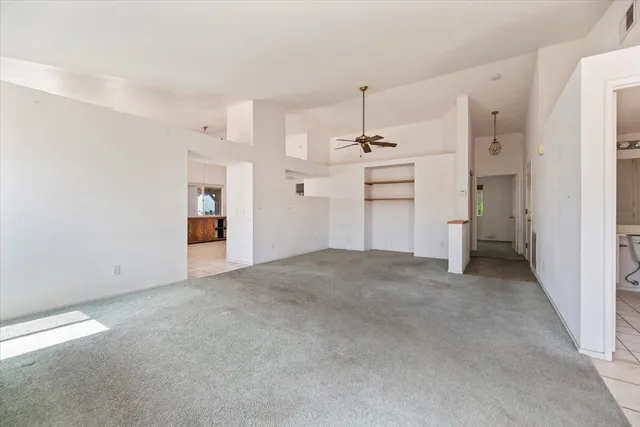 a view of empty room with a kitchen