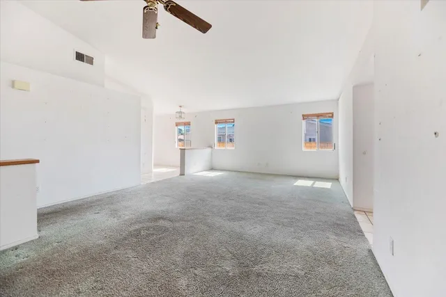 an empty room with ceiling fan and window