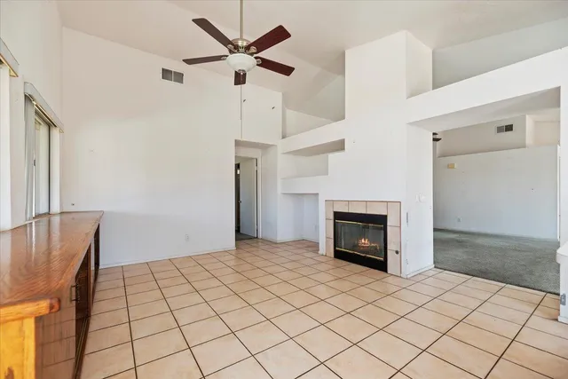 a view of an empty room with window and fireplace
