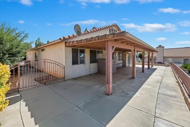a view of a white house with a big yard and potted plants