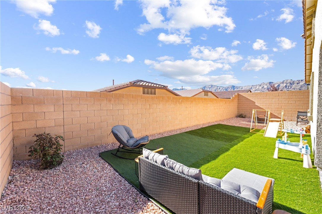 10947 Artisan Ranch Avenue Las Vegas, NV 89166 - Photo 31 of 39 Fenced backyard featuring a mountain view, a patio, and outdoor lounge area