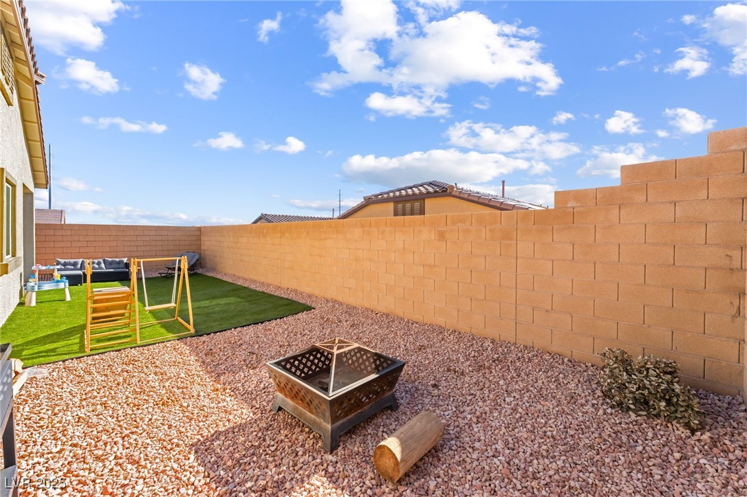 10947 Artisan Ranch Avenue Las Vegas, NV 89166 - Photo 34 of 39 Fenced backyard with a fire pit and a patio