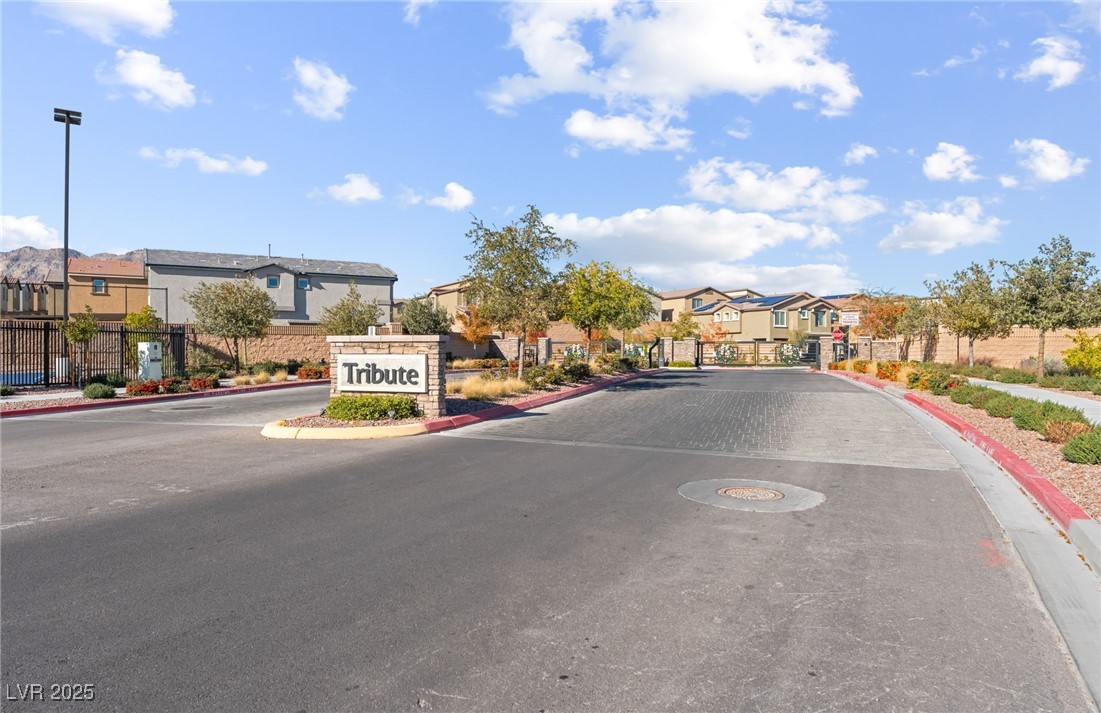 10947 Artisan Ranch Avenue Las Vegas, NV 89166 - Photo 37 of 39 View of asphalt street with a residential view, curbs, a gated entry, a gate, and sidewalks
