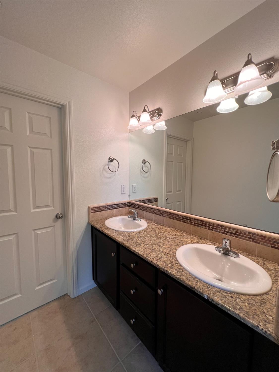 1504 Mosaic Way Clovis, CA 93619 - Photo 26 of 34 a bathroom with a granite countertop double vanity sink and a mirror