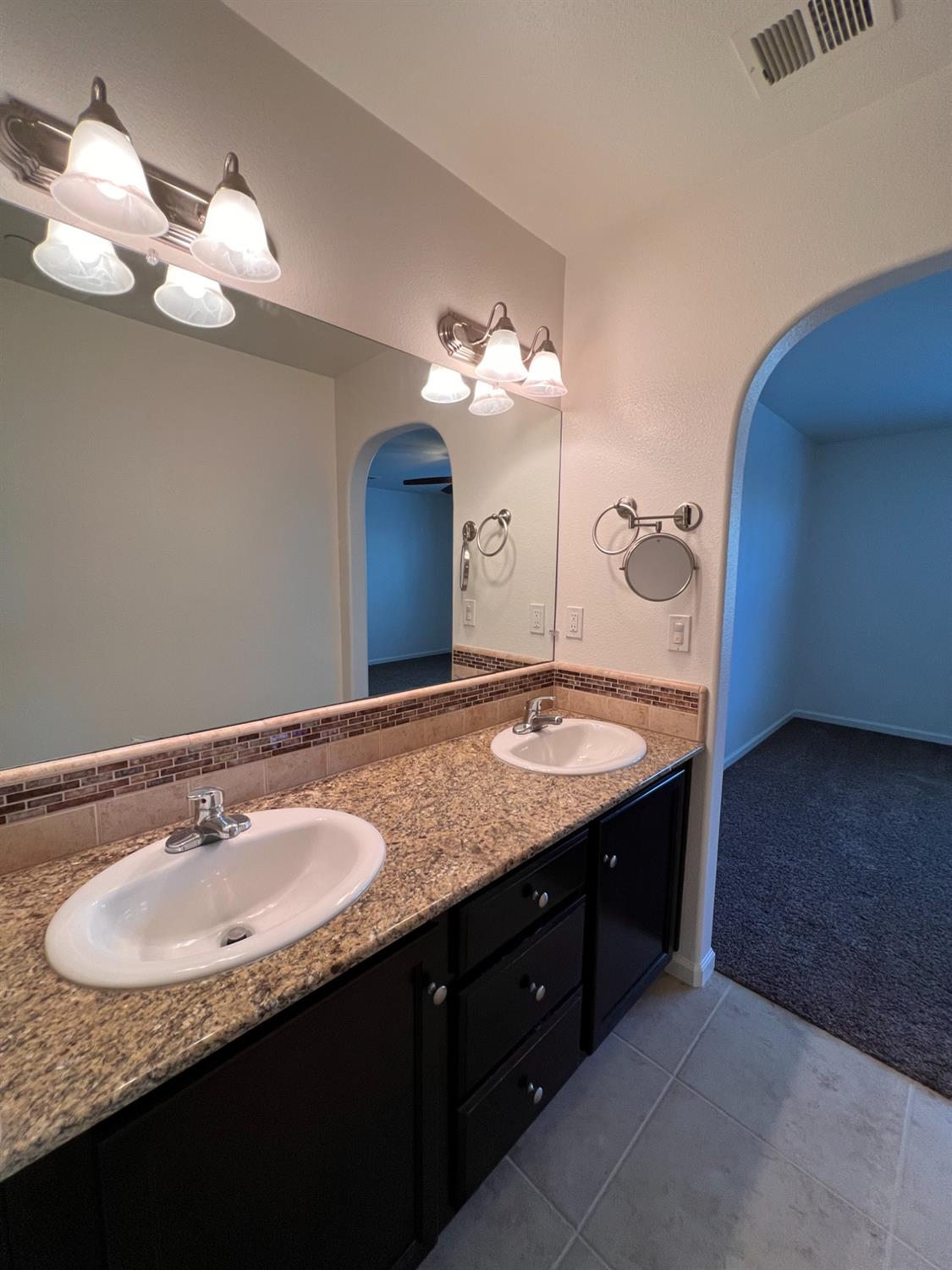 1504 Mosaic Way Clovis, CA 93619 - Photo 28 of 34 a bathroom with a granite countertop sink a large mirror and vanity