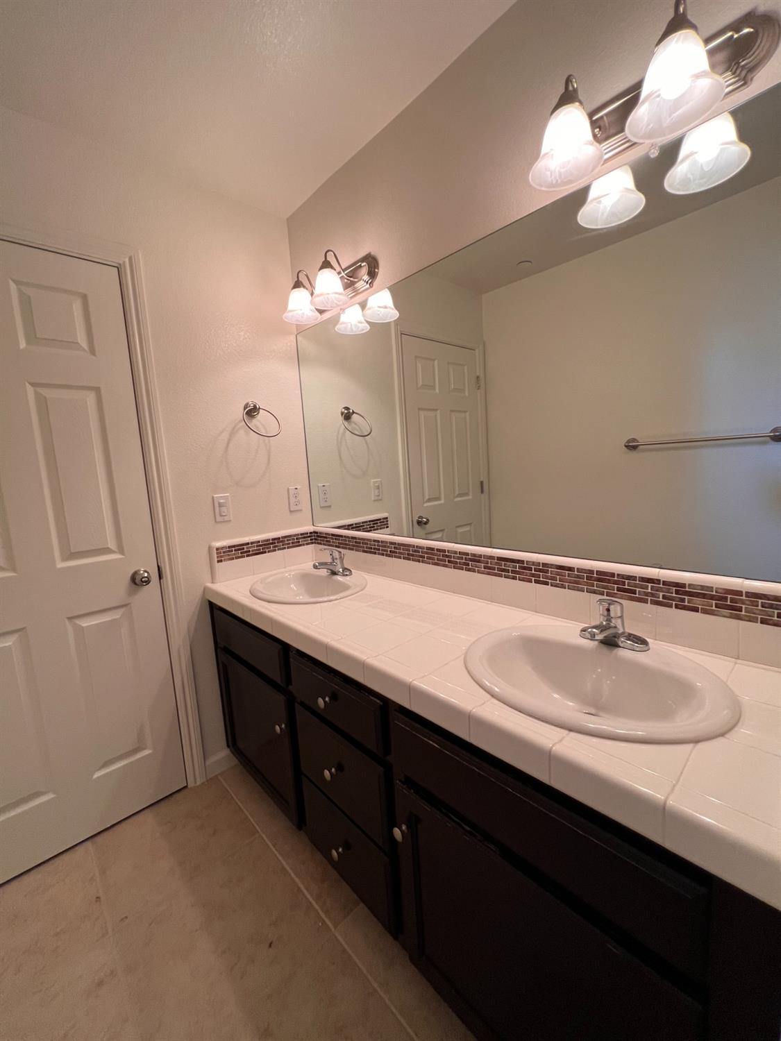 1504 Mosaic Way Clovis, CA 93619 - Photo 30 of 34 a bathroom with a double vanity sink and a mirror