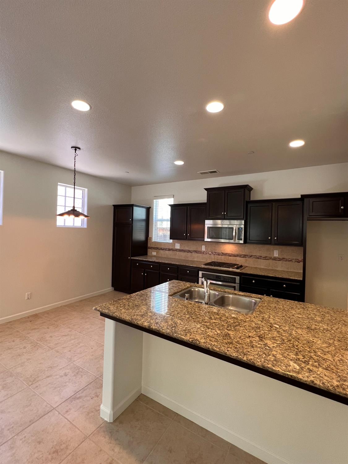 1504 Mosaic Way Clovis, CA 93619 - Photo 10 of 34 a kitchen with stainless steel appliances granite countertop a sink and a granite counter tops