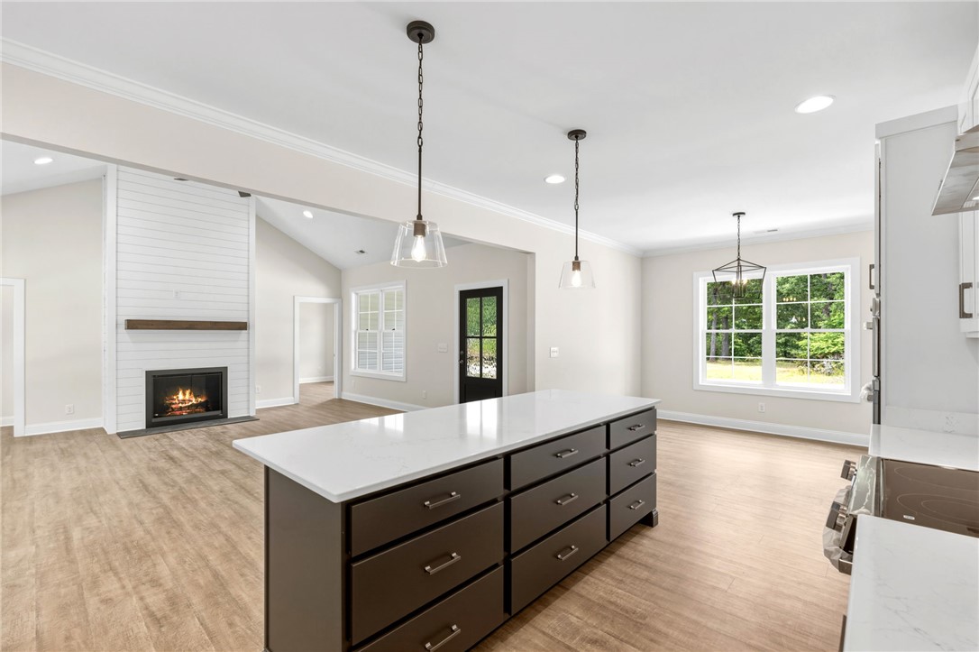 1735 Maw Bridge Road Central, SC 29630 - Photo 13 of 38 An inviting open-concept area features a kitchen island, fireplace, and ample natural light.