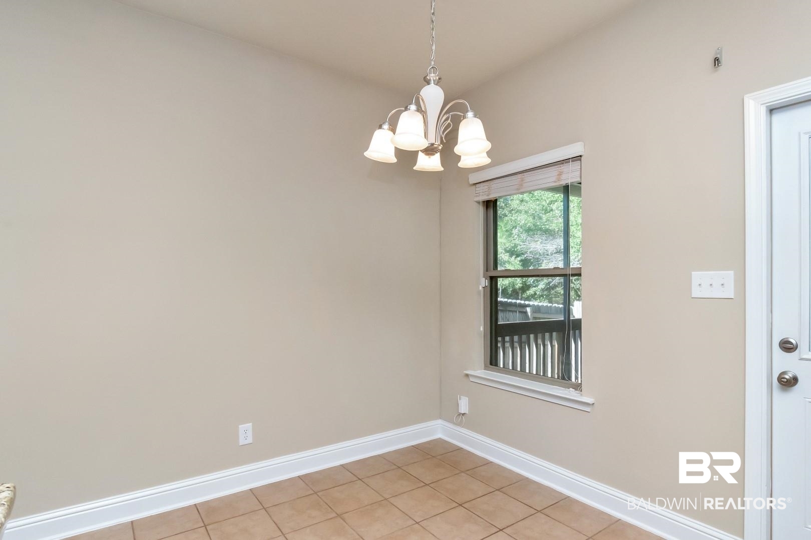 6144 Whitebark Drive Mobile, AL 36693 - Photo 12 of 33 Empty room with light tile patterned flooring and a notable chandelier