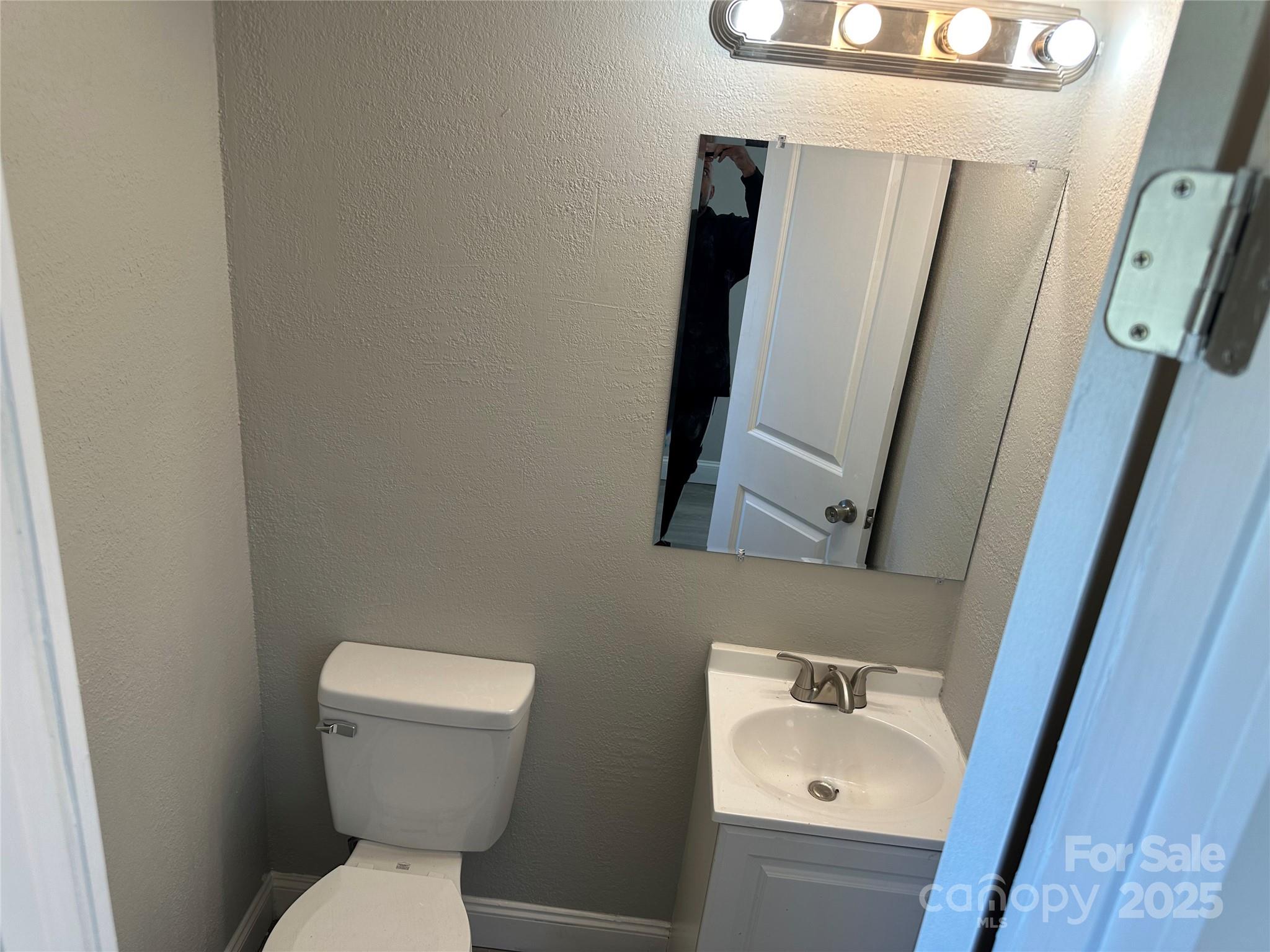 209 Brookview Road Statesville, NC 28625 - Photo 13 of 14 a white toilet sitting next to a sink and a mirror
