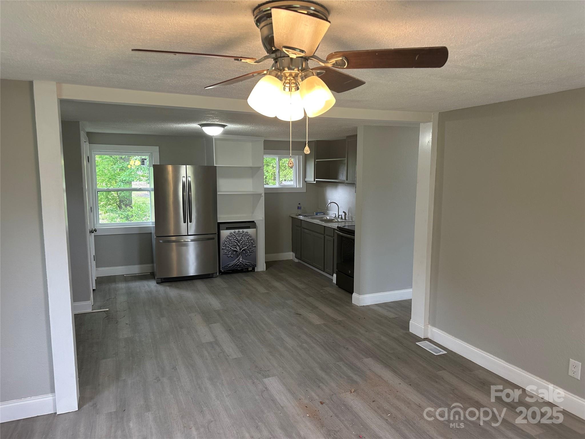 209 Brookview Road Statesville, NC 28625 - Photo 2 of 14 a kitchen with stainless steel appliances granite countertop a refrigerator a sink dishwasher a stove and a dining table with wooden floor