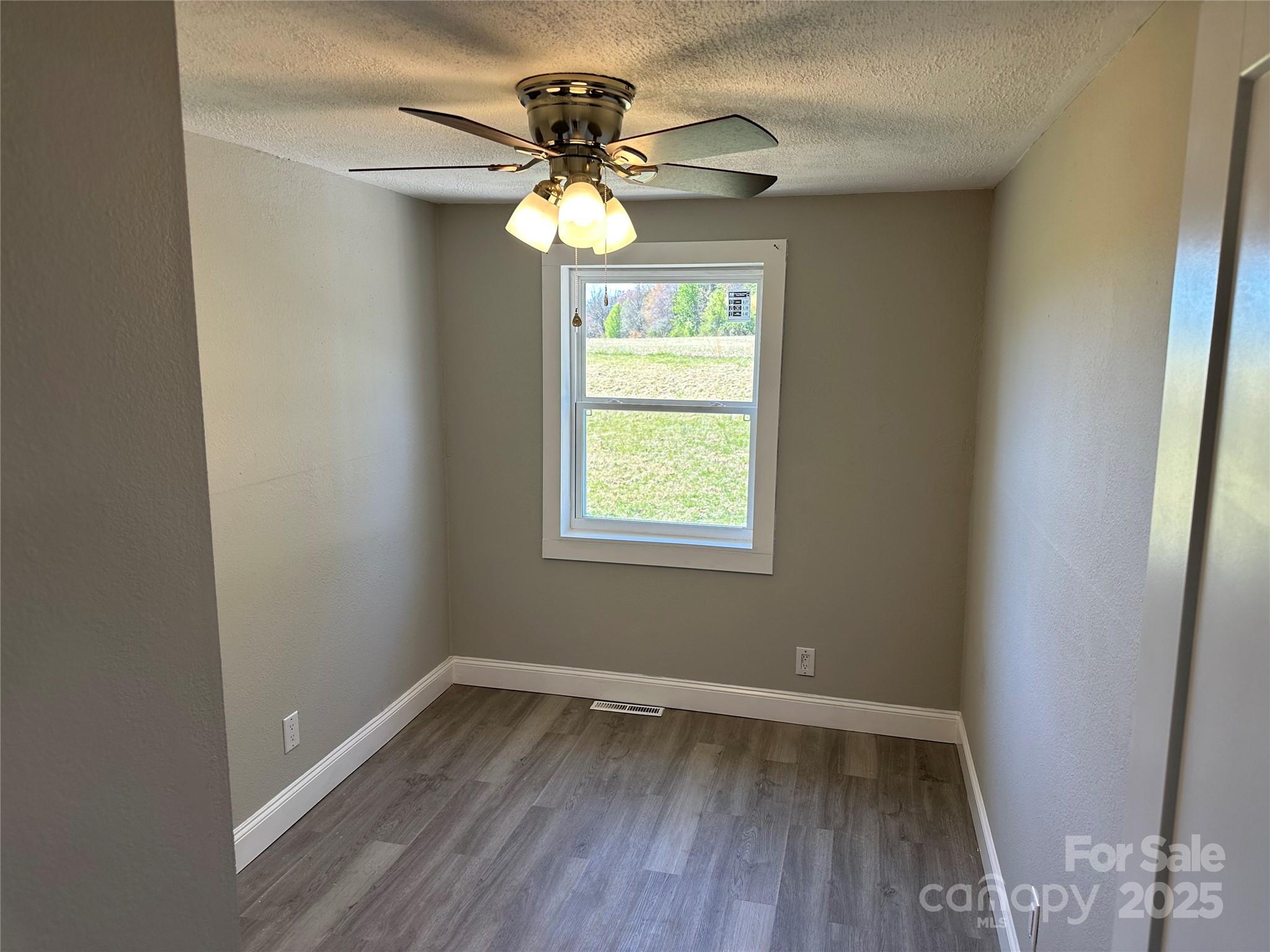 209 Brookview Road Statesville, NC 28625 - Photo 9 of 14 a view of an empty room with wooden floor and a window