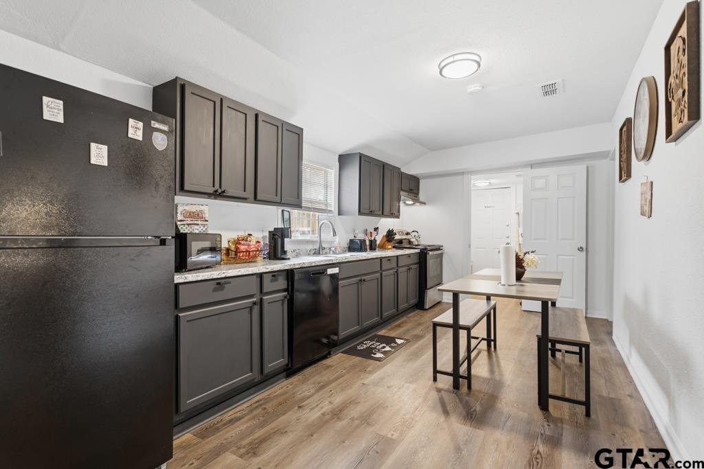 10124 County Road 280 Tyler, TX 75702 - Photo 16 of 47 a kitchen with a refrigerator a table and chairs in it