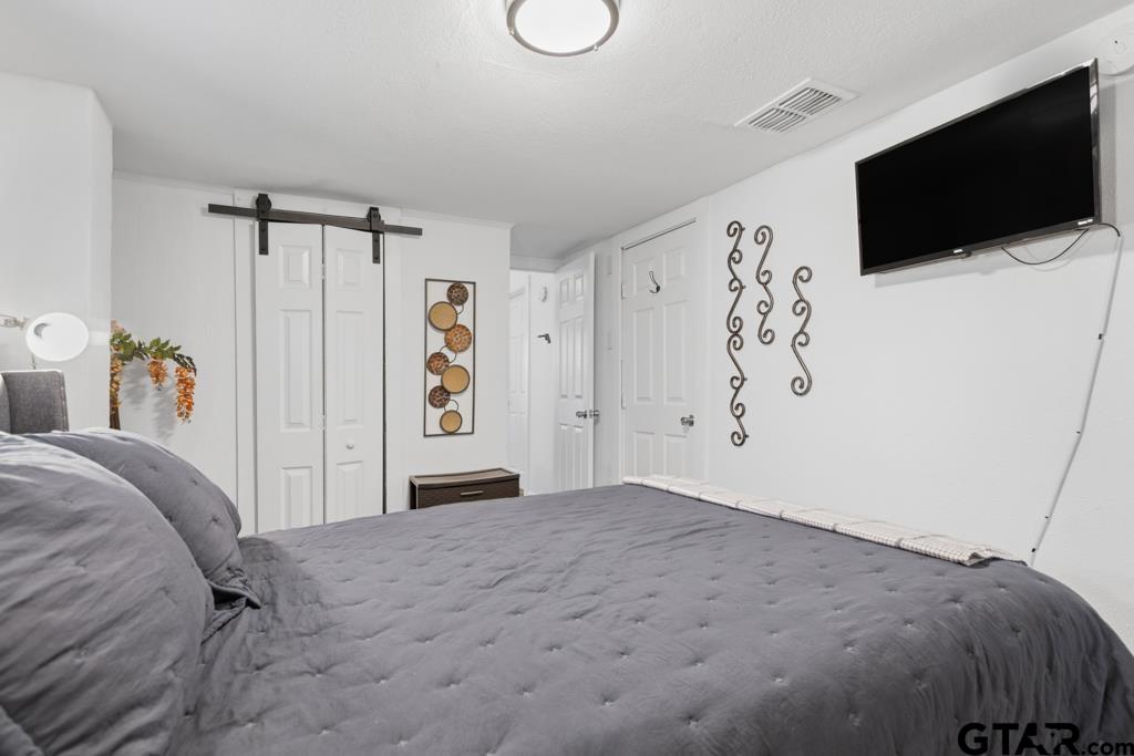 10124 County Road 280 Tyler, TX 75702 - Photo 23 of 47 a bedroom with a bed and a flat screen tv