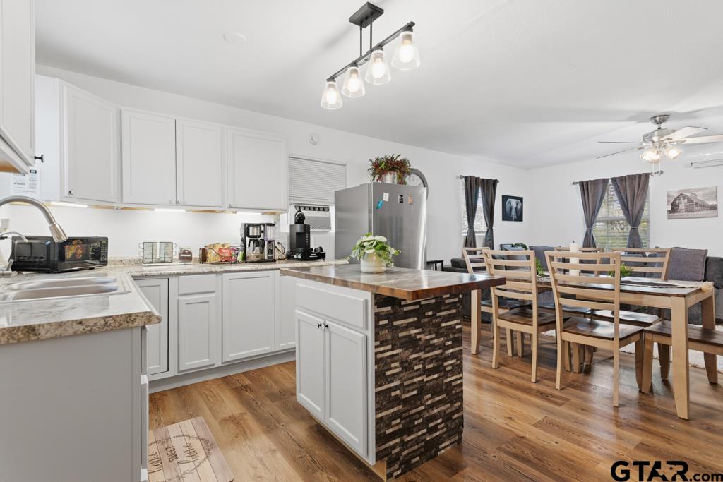 10124 County Road 280 Tyler, TX 75702 - Photo 33 of 47 a kitchen with stainless steel appliances kitchen island granite countertop a table chairs sink and cabinets