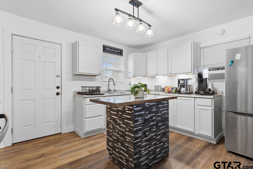 10124 County Road 280 Tyler, TX 75702 - Photo 35 of 47 a kitchen with stainless steel appliances granite countertop a refrigerator a sink dishwasher a stove and white cabinets with wooden floor