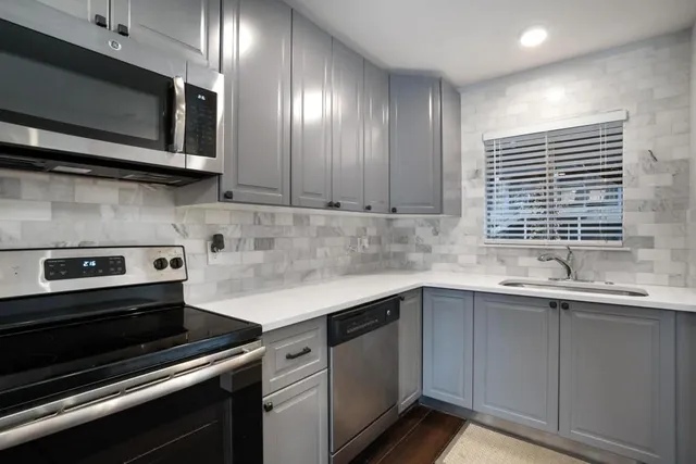 a kitchen with stainless steel appliances a sink stove and cabinets