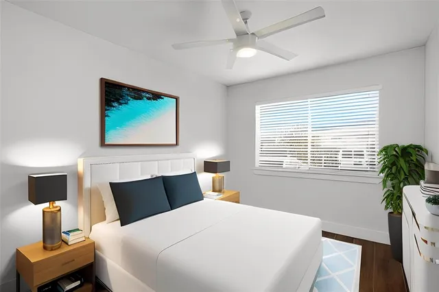 a bedroom with a bed and a table with potted plants