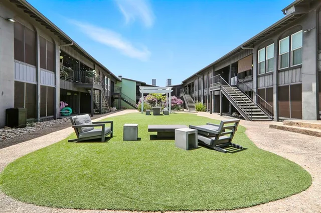a house view with a sitting space fire pit and outdoor space