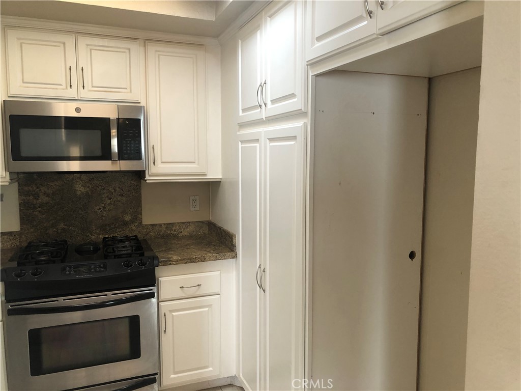 65 Orchard Irvine, CA 92618 - Photo 6 of 21 a kitchen with granite countertop white cabinets and stainless steel appliances