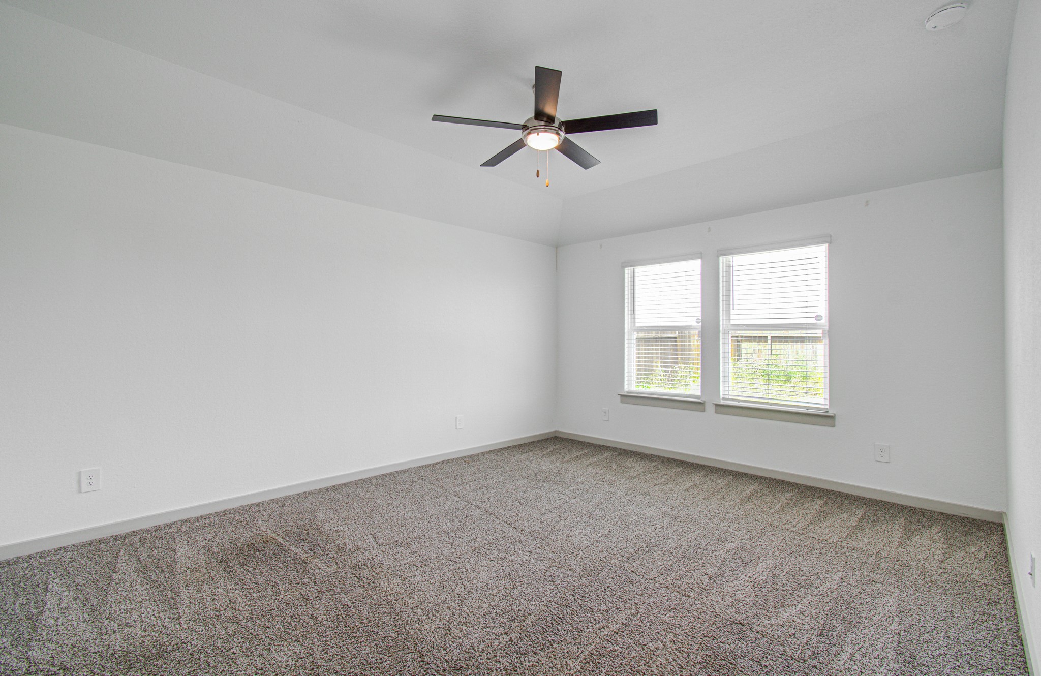 7903 Wrangler Shack Lane Rosharon, TX 77583 - Photo 23 of 29 This bright and spacious bedroom features neutral carpeting, a stylish ceiling fan, and two windows that flood the space with natural light, creating a warm and inviting atmosphere.