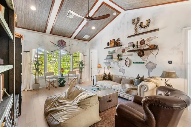 a living room with furniture fireplace and large windows