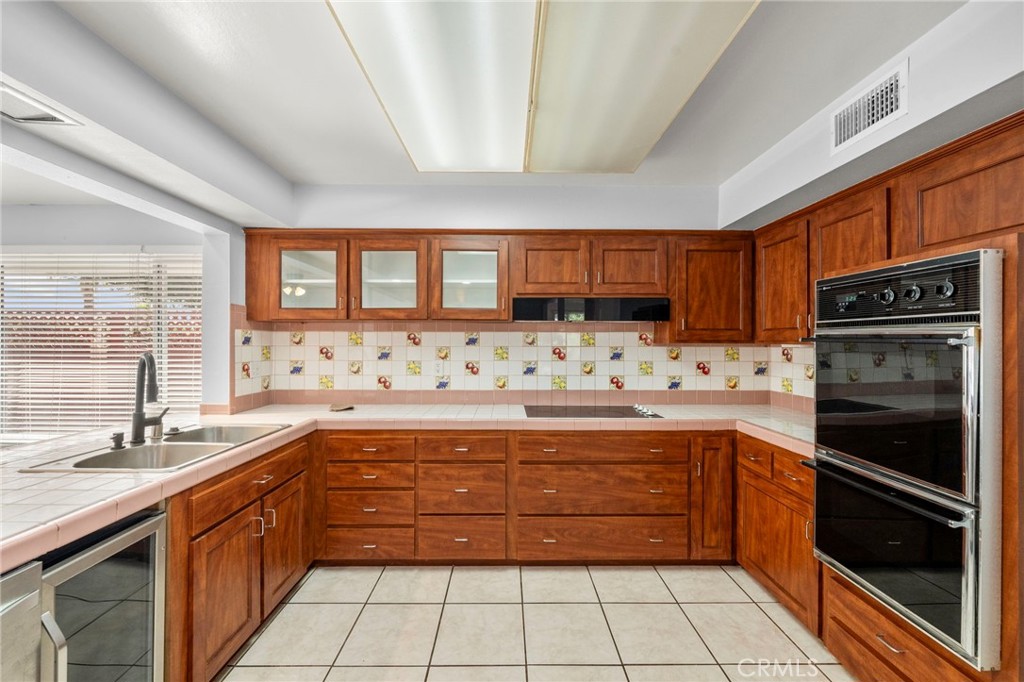 25915 Roanoke Road Menifee, CA 92586 - Photo 21 of 58 a kitchen with stainless steel appliances granite countertop a stove sink and cabinets