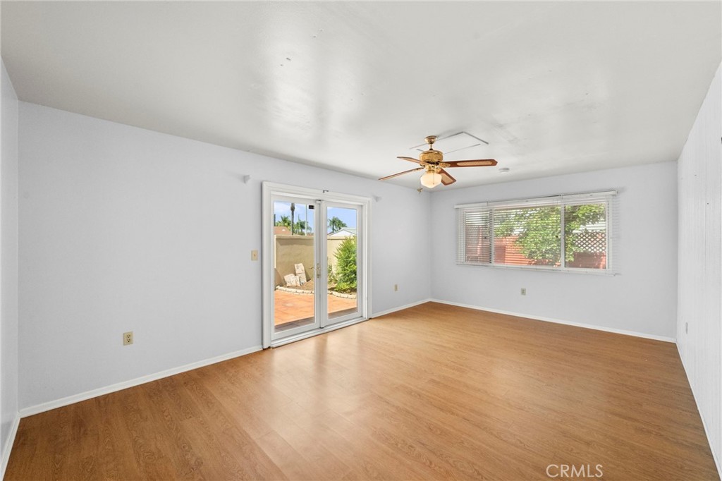25915 Roanoke Road Menifee, CA 92586 - Photo 7 of 58 an empty room with windows and chandelier fan