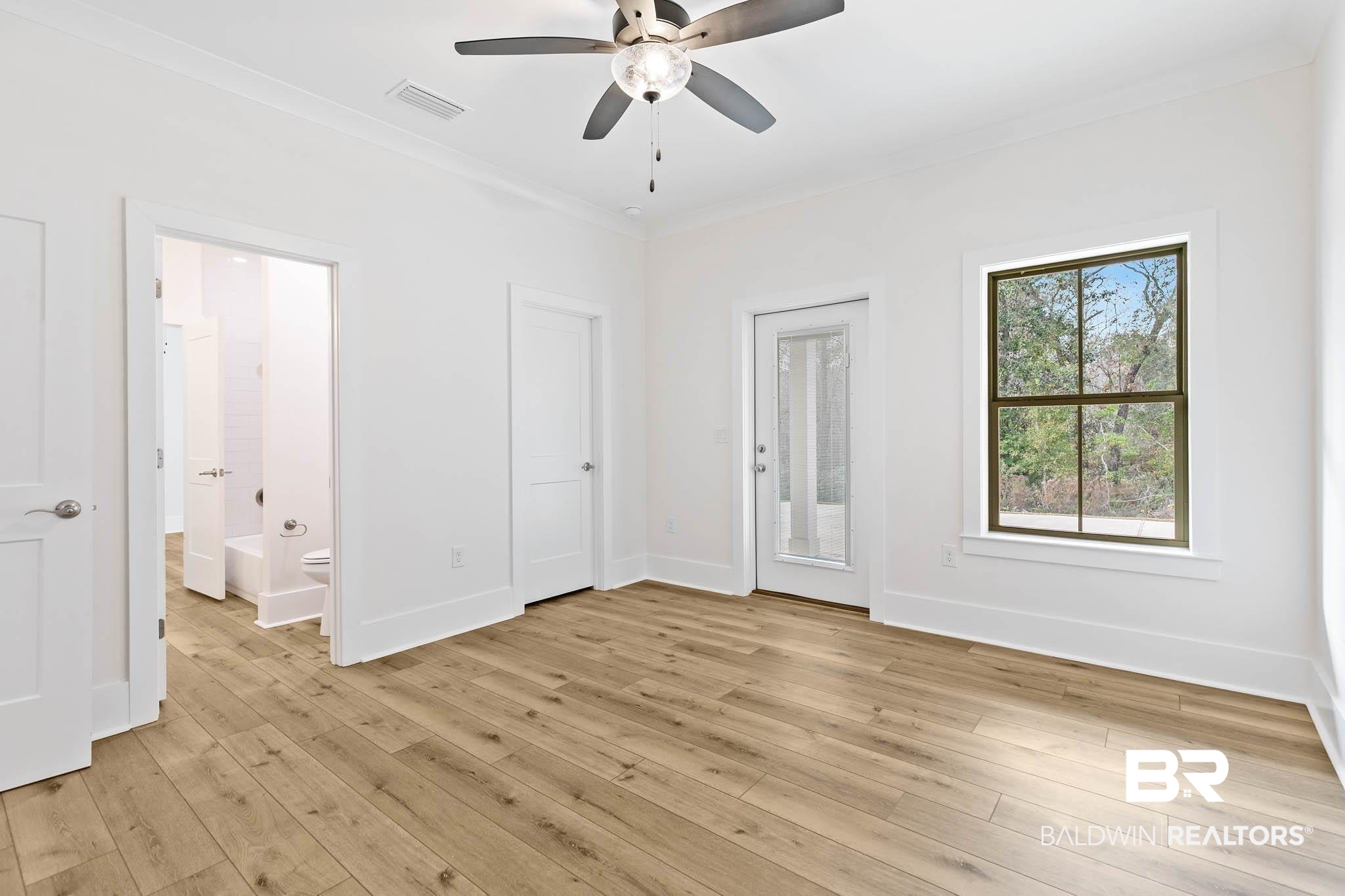 6656 Garrison Drive Daphne, AL 36527 - Photo 42 of 57 Unfurnished bedroom featuring crown molding, light wood finished floors, a ceiling fan, ensuite bathroom, and access to outside