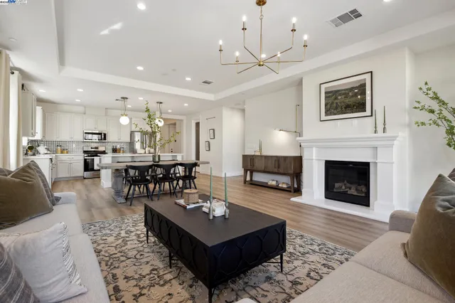 a living room with furniture a fireplace and a chandelier