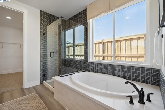 a en suite spacious bathroom with a tub sink and mirror