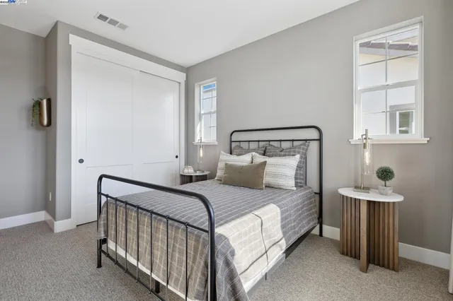 a bedroom with a bed and windows