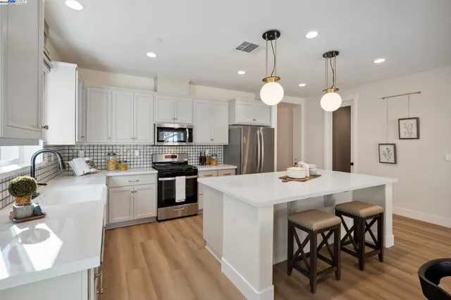 a kitchen with a center island appliances and cabinets