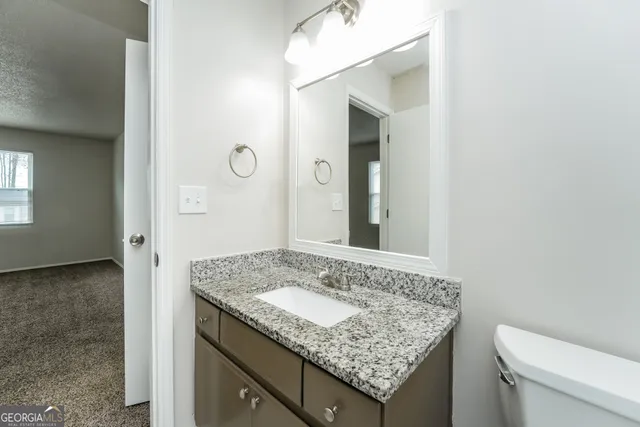 a bathroom with a granite countertop sink and a mirror