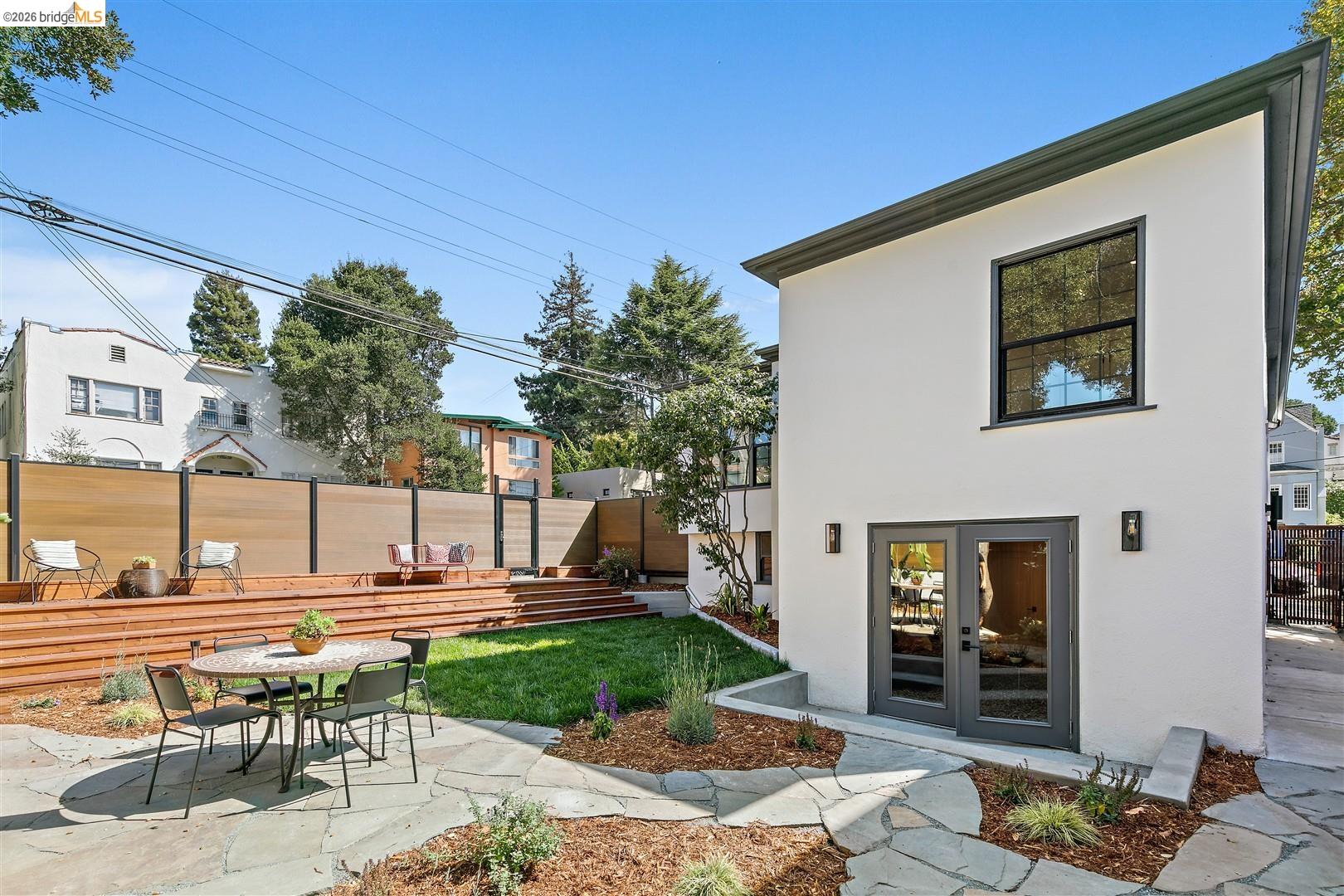 1668 Arch Street Berkeley, CA 94709 - Photo 46 of 78 Expansive outdoor living area featuring a stone patio, manicured lawn, and multi-level wood deck