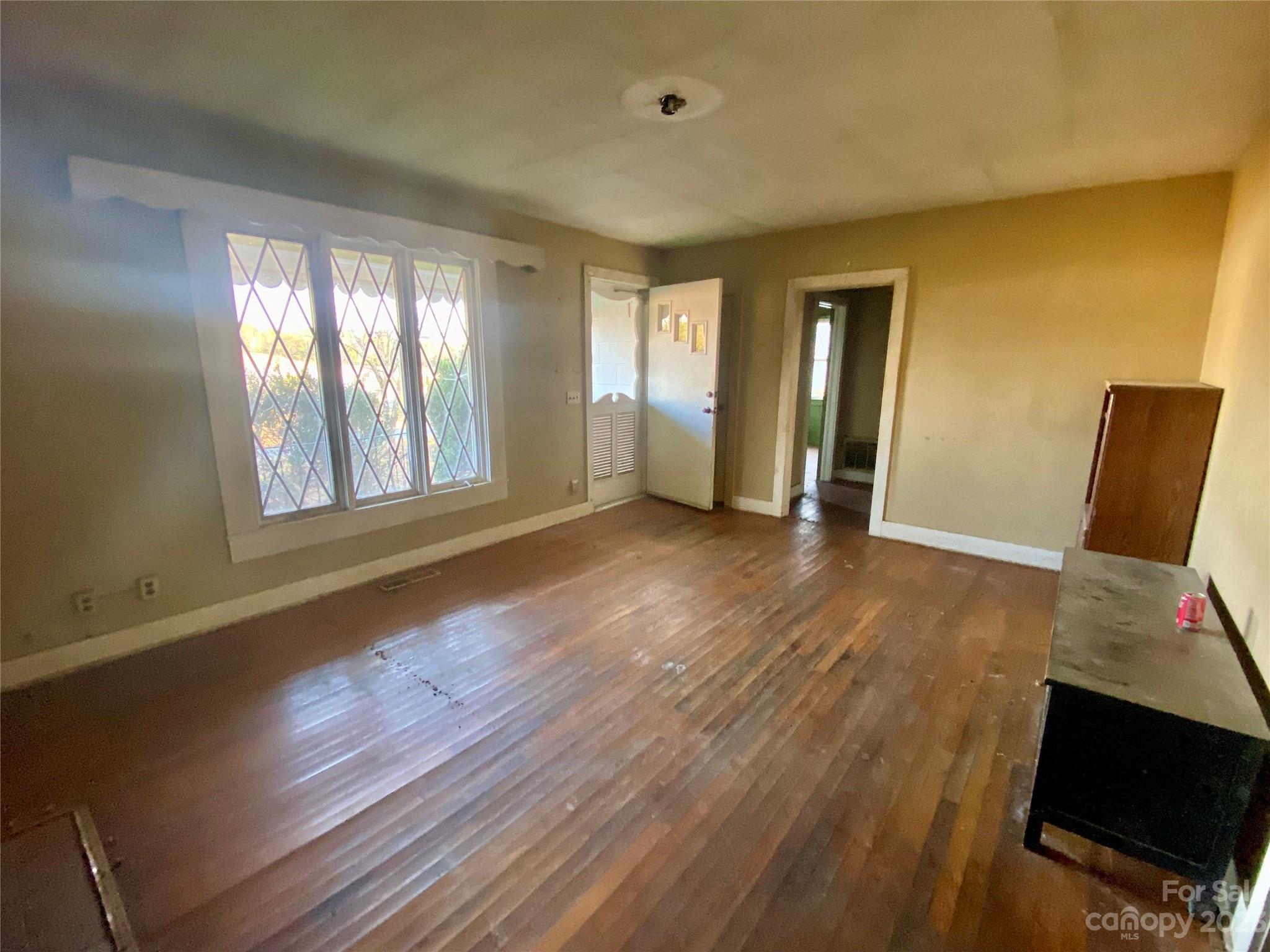 793 Silver Creek Road Mill Spring, NC 28756 - Photo 12 of 20 a view of an empty room with wooden floor and a window