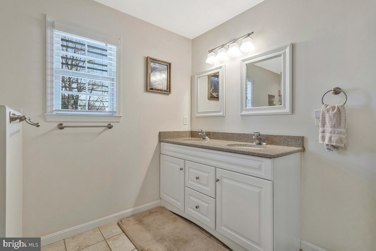 1713 Shore Drive Edgewater, MD 21037 - Photo 22 of 44 a bathroom with a granite countertop sink a toilet and a mirror