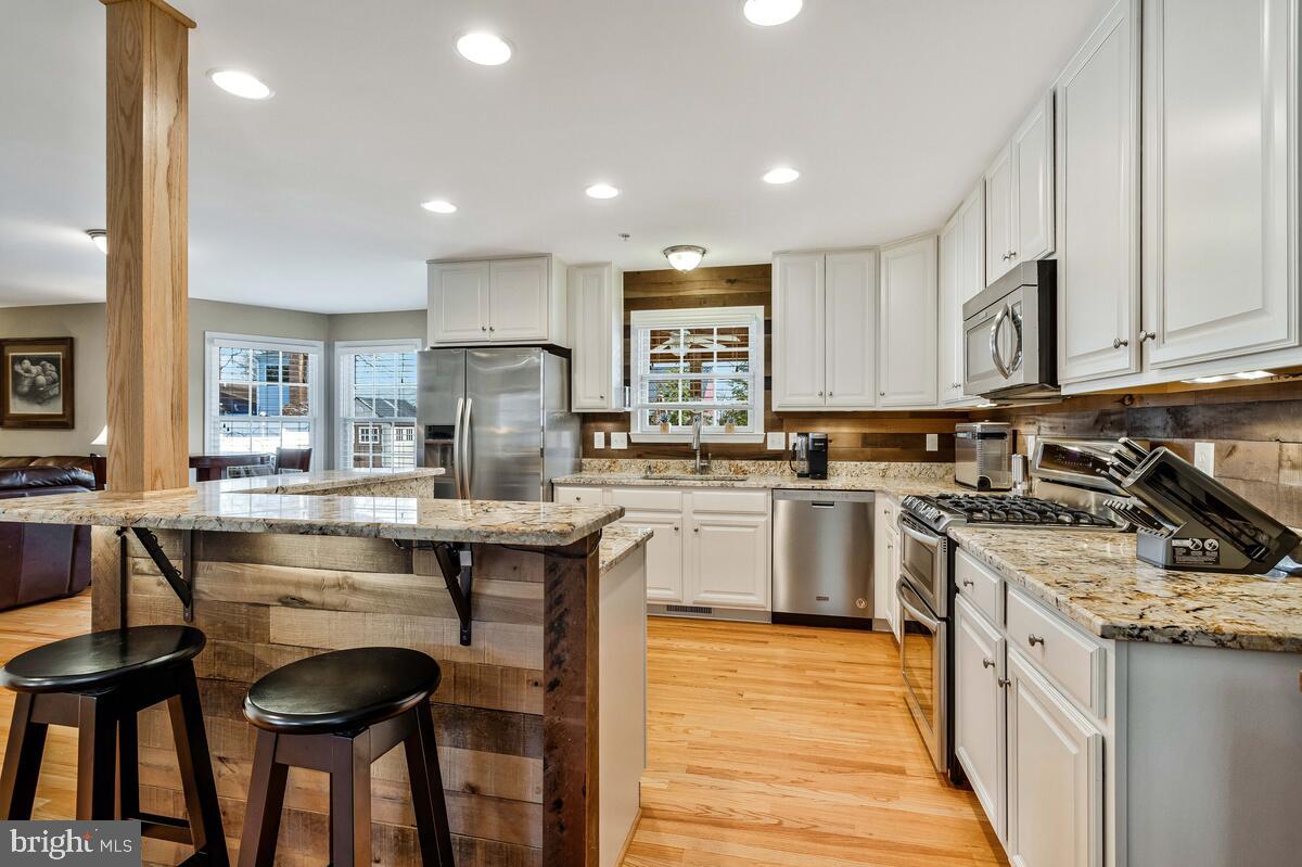 1713 Shore Drive Edgewater, MD 21037 - Photo 9 of 44 a kitchen with stainless steel appliances granite countertop wooden cabinets stove top oven and sink