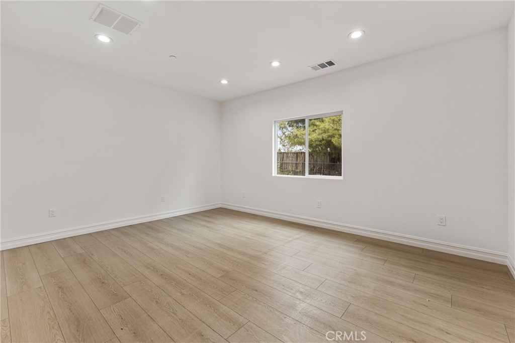 230 East Hoffer Street Banning, CA 92220 - Photo 11 of 32 an empty room with wooden floor and window