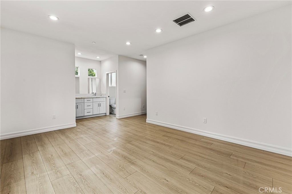 230 East Hoffer Street Banning, CA 92220 - Photo 12 of 32 an empty room with wooden floor & windows