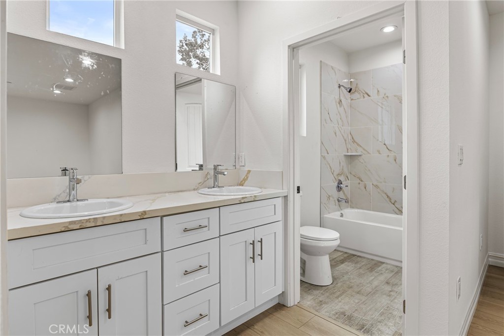 230 East Hoffer Street Banning, CA 92220 - Photo 13 of 32 a bathroom with a double vanity sink toilet and shower