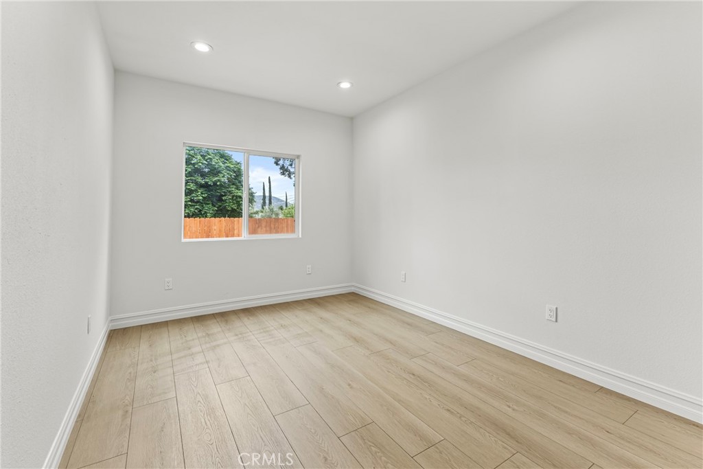 230 East Hoffer Street Banning, CA 92220 - Photo 16 of 32 an empty room with wooden floor and windows