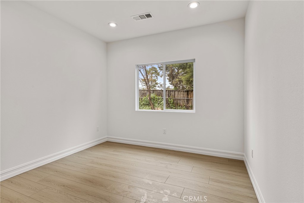 230 East Hoffer Street Banning, CA 92220 - Photo 18 of 32 an empty room with wooden floor and windows