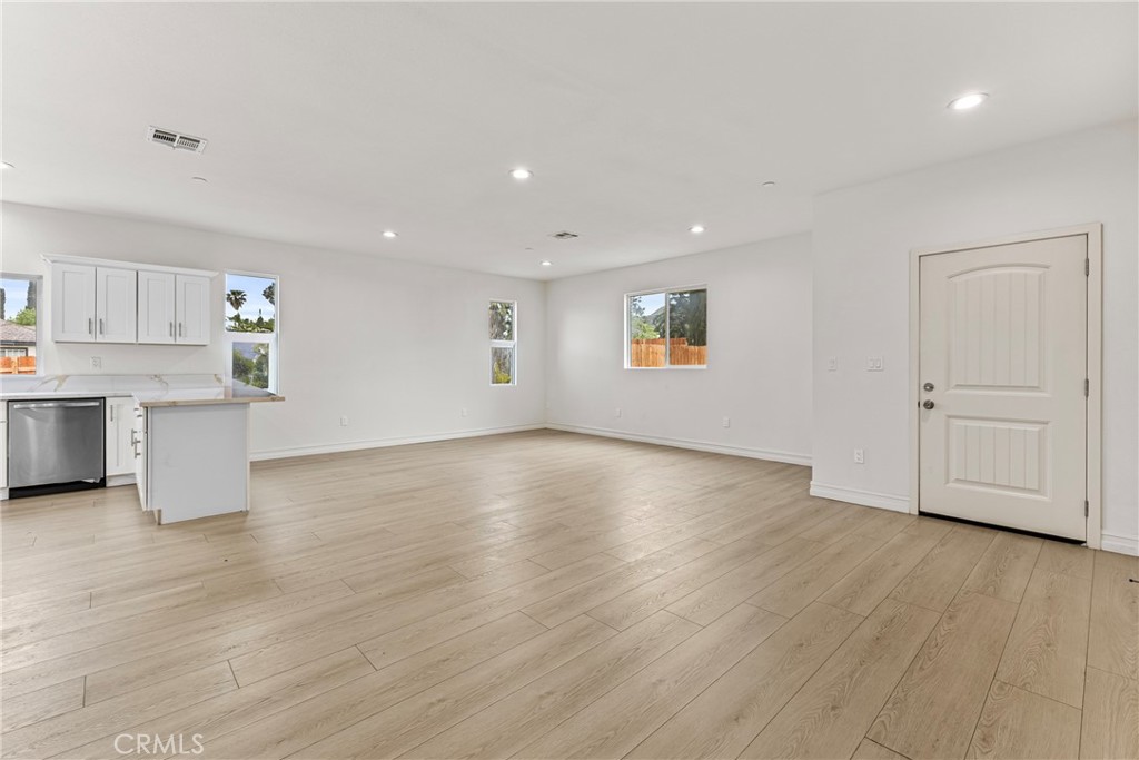 230 East Hoffer Street Banning, CA 92220 - Photo 6 of 32 a view of an empty room with wooden floor and a window