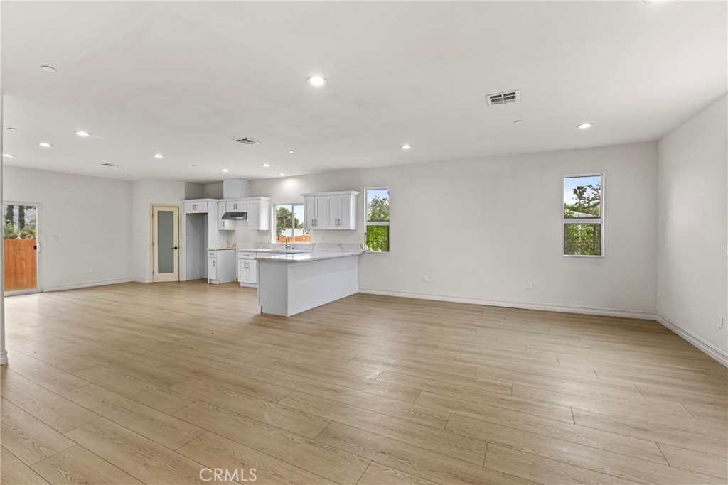 230 East Hoffer Street Banning, CA 92220 - Photo 7 of 32 an empty room with wooden floor and windows
